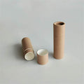 Two brown cylindrical containers standing upright with one lying horizontally open, showing a light interior, on a grey background.