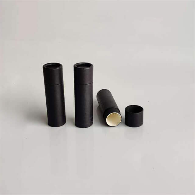Three standing black cylindrical containers with one lying horizontally open, revealing a light interior, on a grey background.