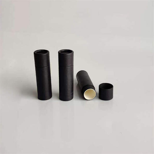 Three standing black cylindrical containers with one lying horizontally open, revealing a light interior, on a grey background.